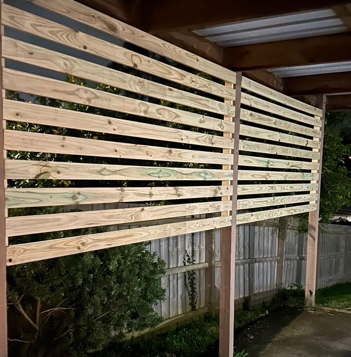 Timber slat screening added above the existing fence under a carport